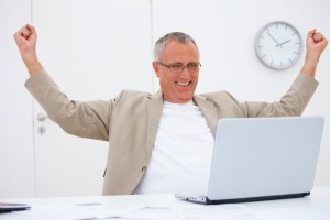 Happy successful business man with a laptop